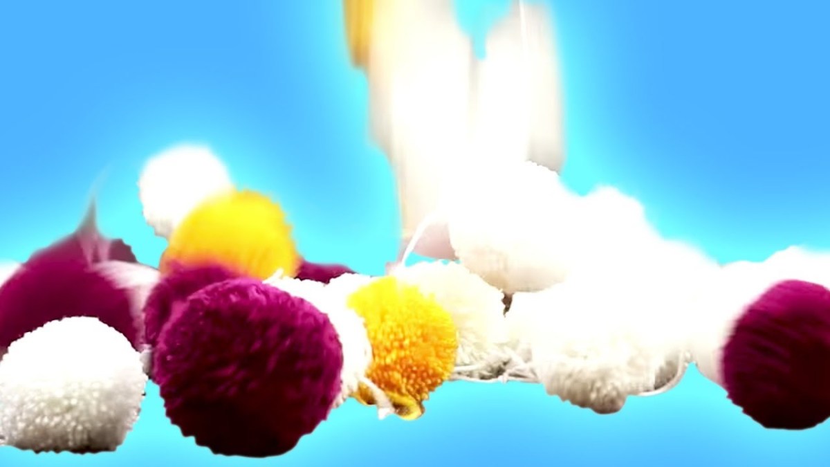 Ein Bild von einem Bommelteppich vor blauem Hintergrund.