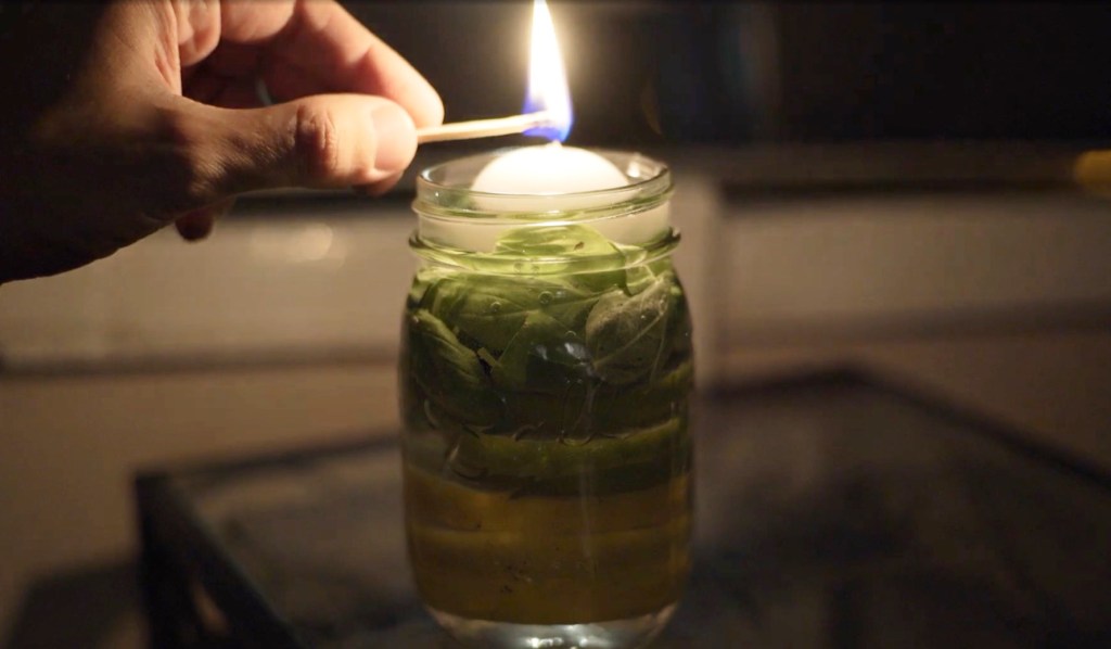 Eine DIY-Mückenkerze in einem Einmachglas wird angezündet.