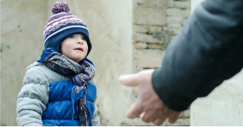 Sicher im Alltag: unbekannte Hand geht auf einen kleinen Jungen zu
