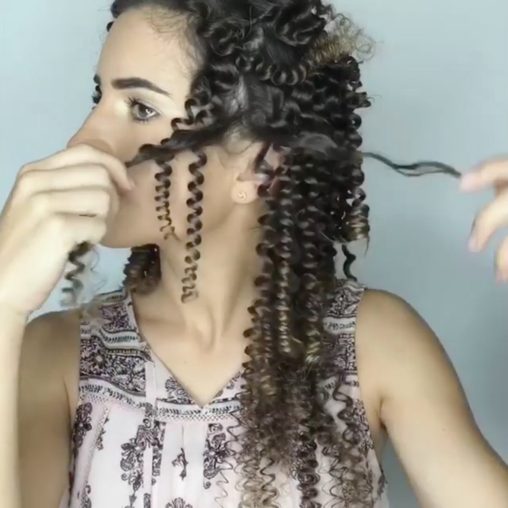 Eine Frau entwirrt ihre lockigen Haare.