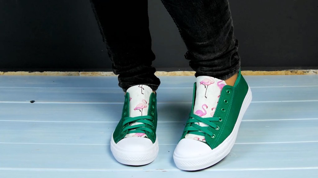 Grüne Chucks mit Flamingo-Motiven auf den Laschen.