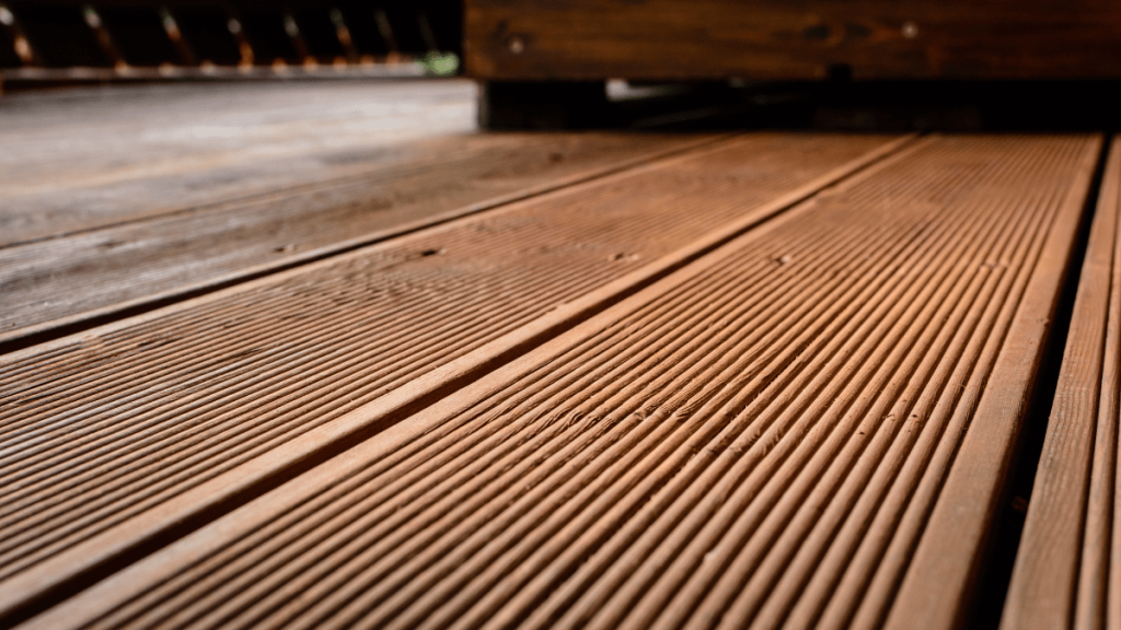 Holzterrasse mit Besen und Gartenschlauch reinigen: So geht’s