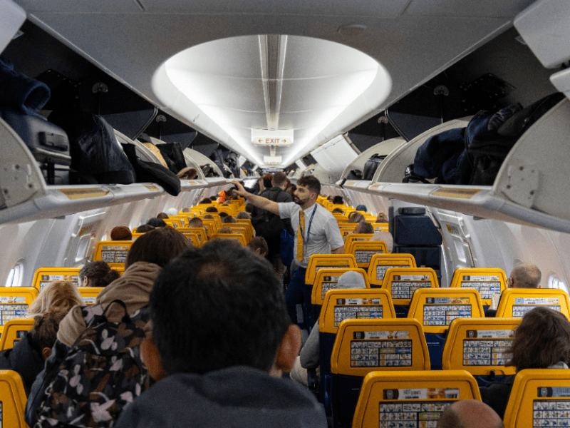 Viele Menschen beim Einstiegen und Sitzplatzsuche in einem Flugzeug.