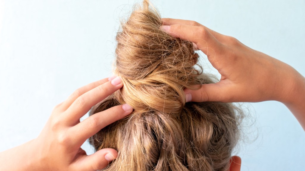 Ein Messy Bun einer blonden Frau von hinten und nah fotografiert.