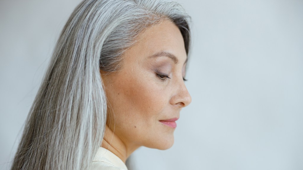 Eine ältere Frau mit langen, grauen Haaren.