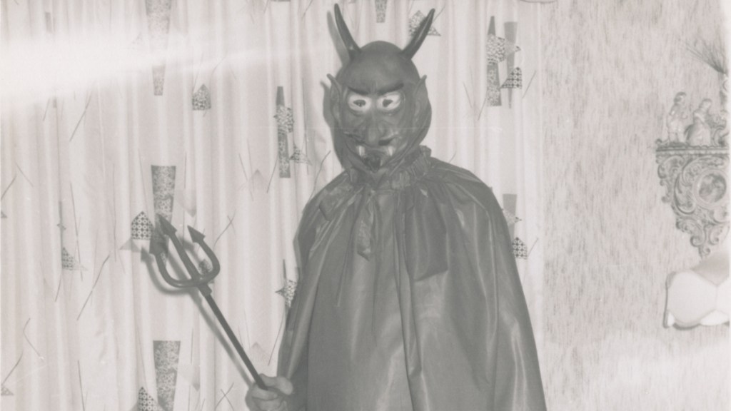 Ein historisches Foto von einem alten Halloween-Kostüm, das einen Mann zeigt, der als Teufel verkleidet ist.