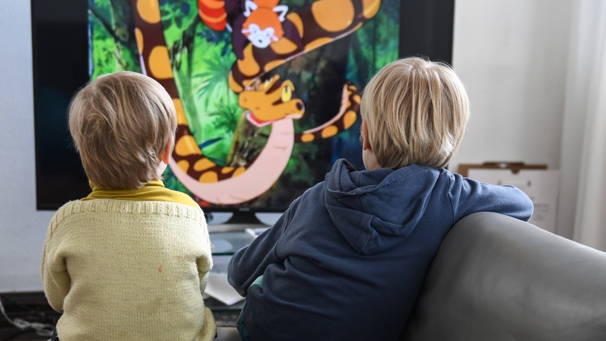Zwei Kinder sehen sich einen Zeichentrickfilm im Fernseher an