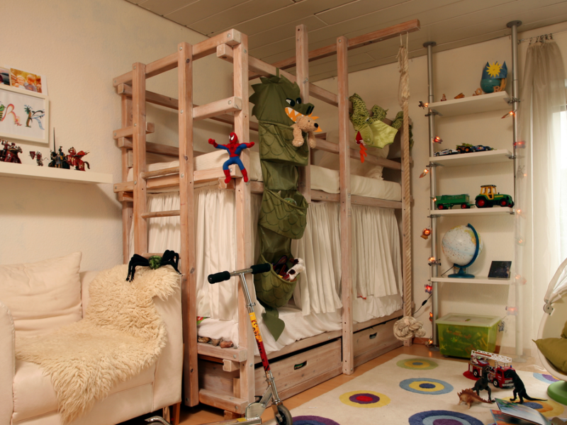 Ein unaufgeräumtes Kinderzimmer mit einem Hochbett.