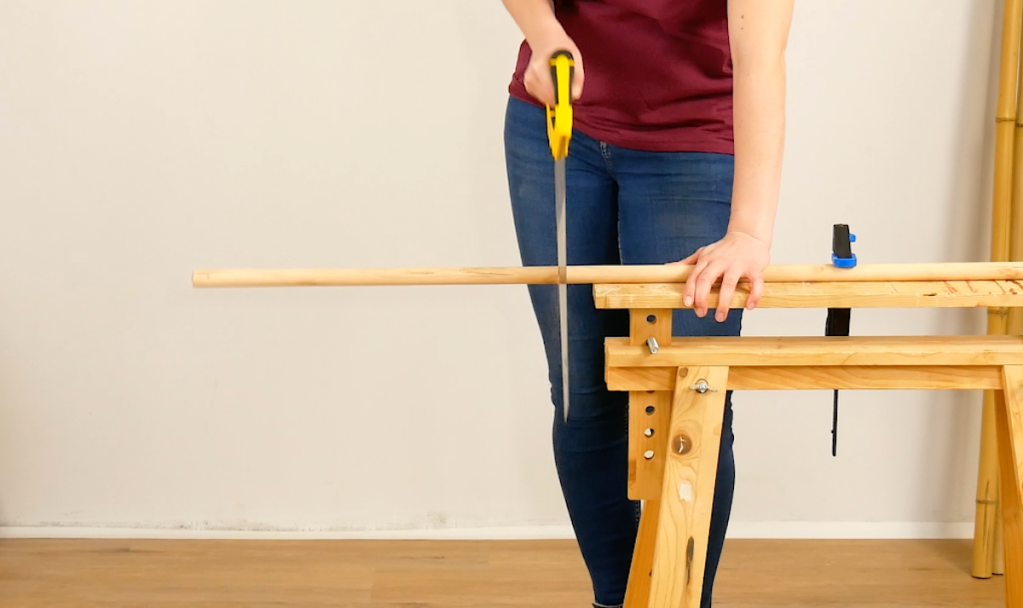 Holzstangen werden in gleich lange Stücke gesägt.