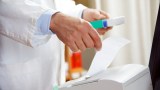 ein Apotheker kassiert ein Medikament ab