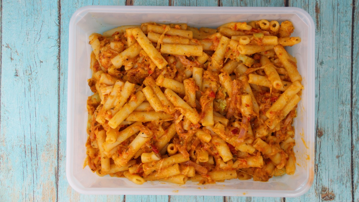 in einer Plastikdose werden Nudeln in Tomatensauce aufbewahrt