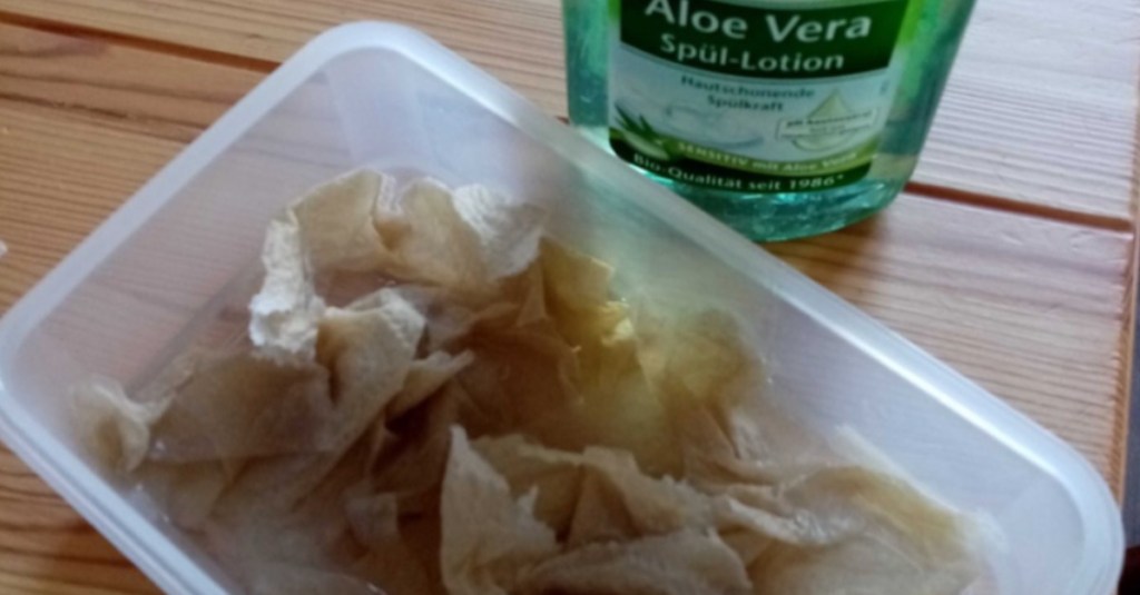 verfärbte Tupperdose wird mit Küchentüchern und Spüli gereinigt