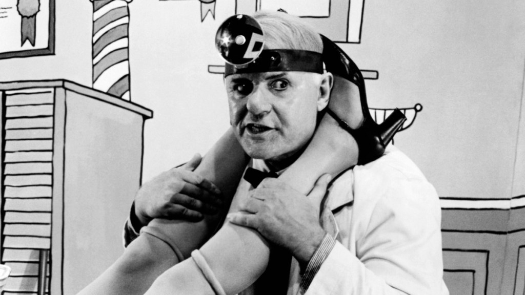 Bild aus dem Film „W.C. Fields and me“ von 1976. Ein Frauenarzt zwischen den Beinen einer Patientin.