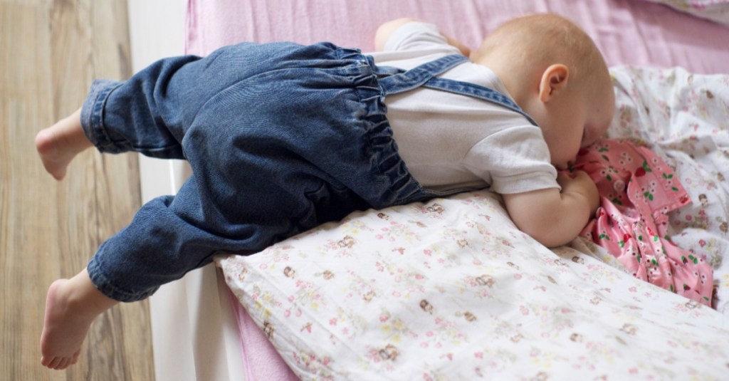 nützliche Produkte Kinder: ein kleines Kind schläft auf einem Bett, die Beine hängen aus dem Bett heraus