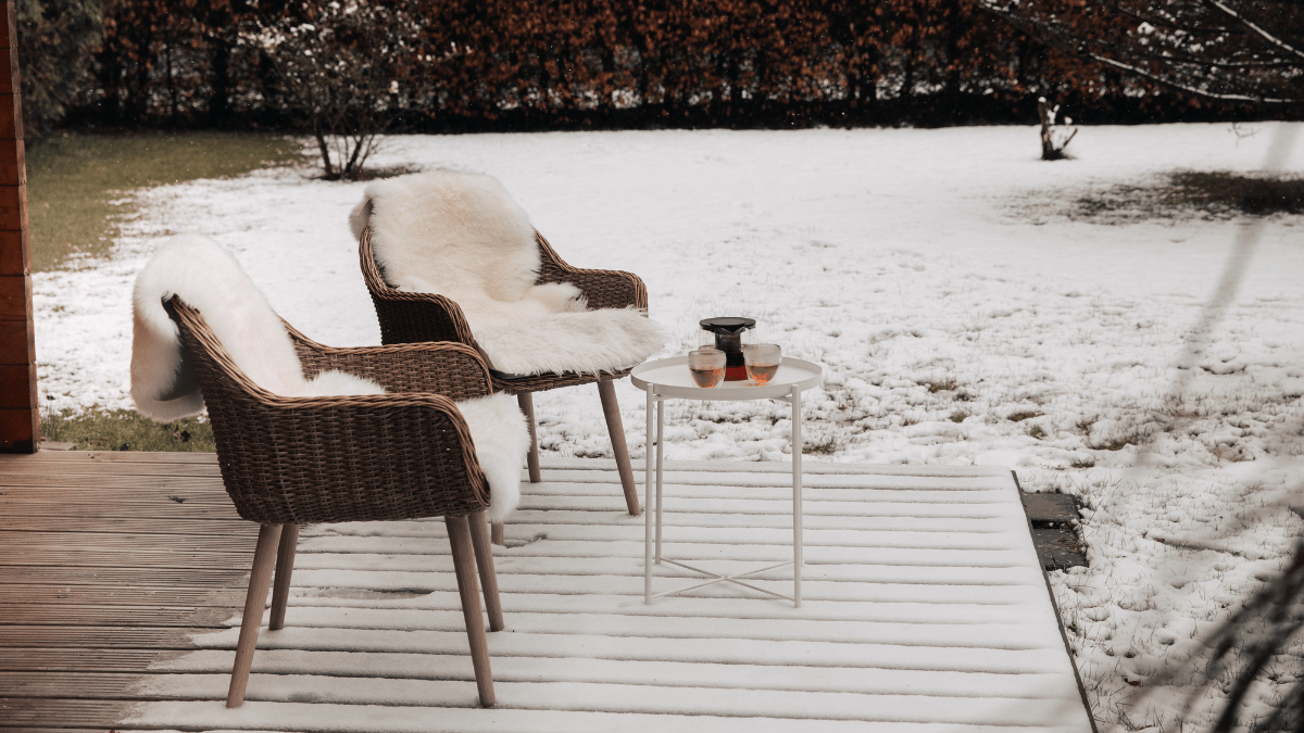 Ein schneeweißer Garten mit Gartenstühlen plus weißem Fell.