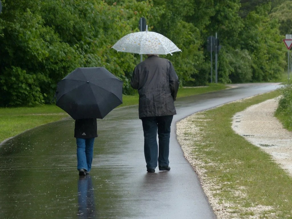 Zwei Menschen bei einem Spaziergang im regen.
