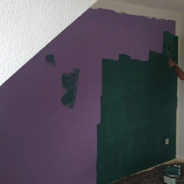 Wand in einer Wohnung streichen.