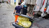 Abfallentsorgung durch den Müllwerker mit dem Müllwagen