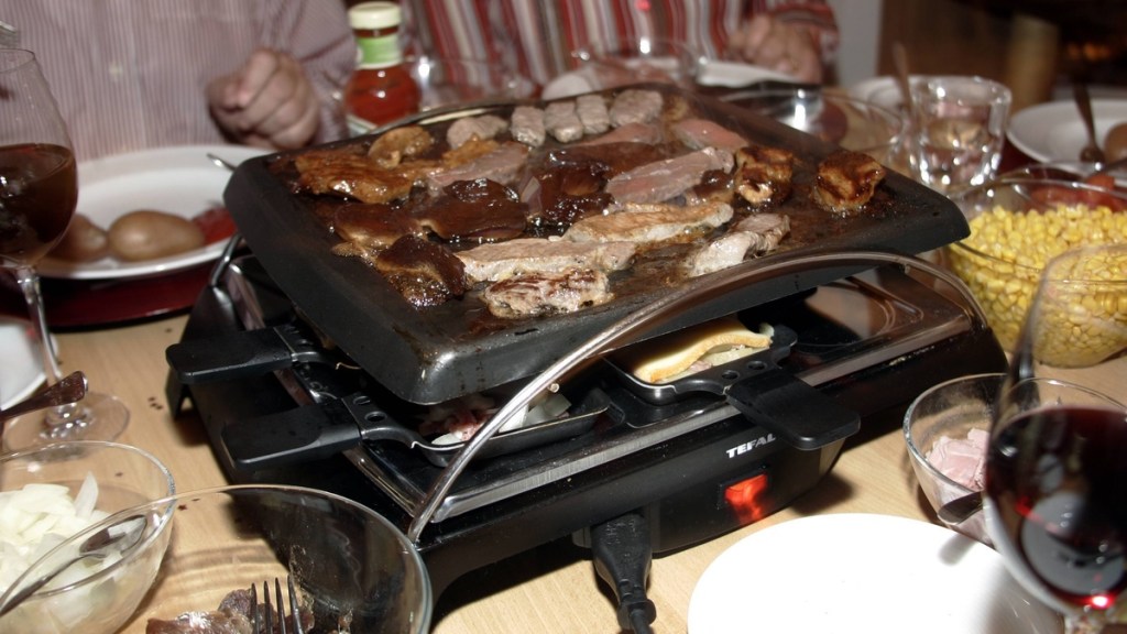 Fleisch wird auf dem Raclette gegrillt.