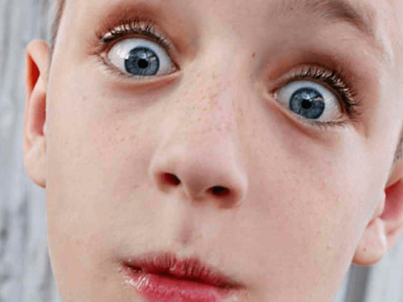 Kind blickt in Nahaufnahme mit großen Augen direkt in die Kamera