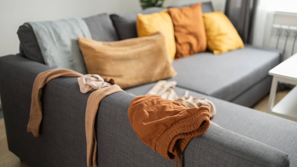 Lässiges häusliches Durcheinander mit Kleidung auf einem modernen Sofa