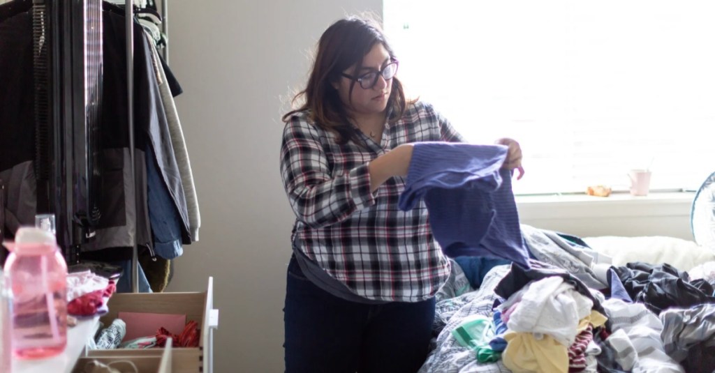 eine Frau verräumt Kleidung