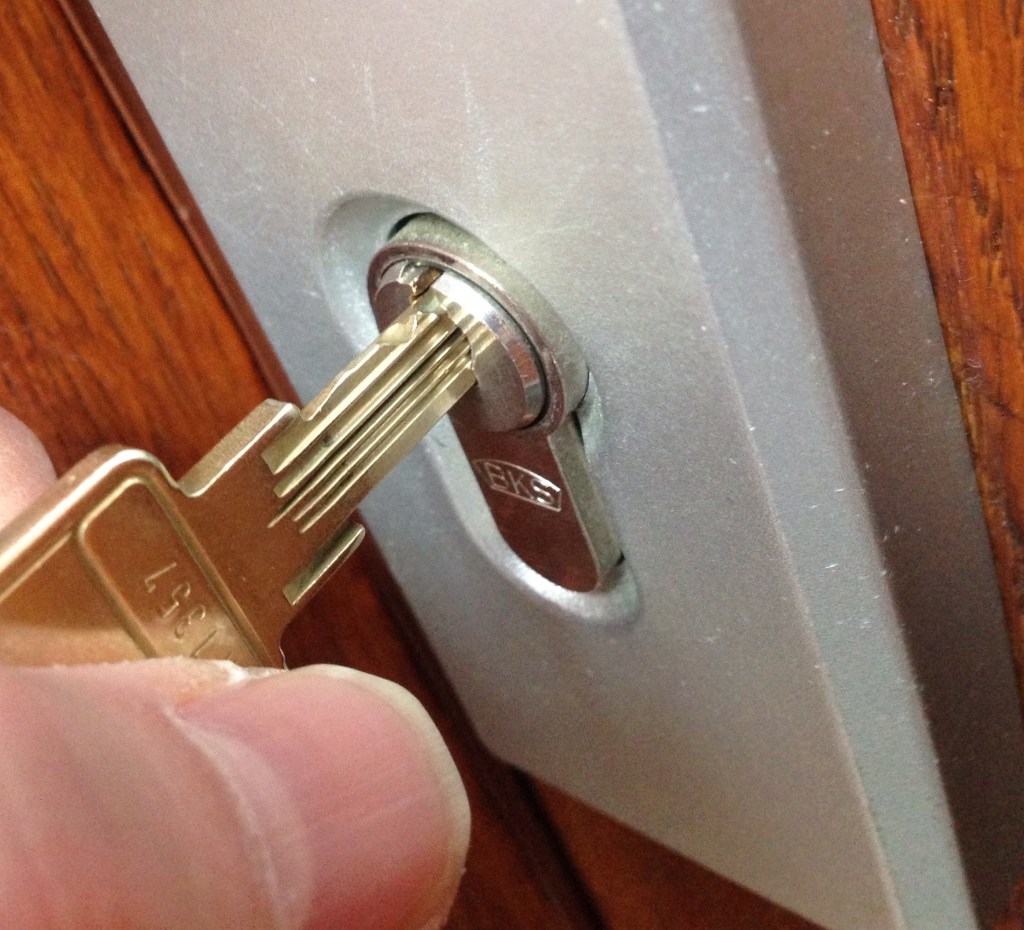 Jemand steckt einen Schlüssel in das Schlüsselloch.