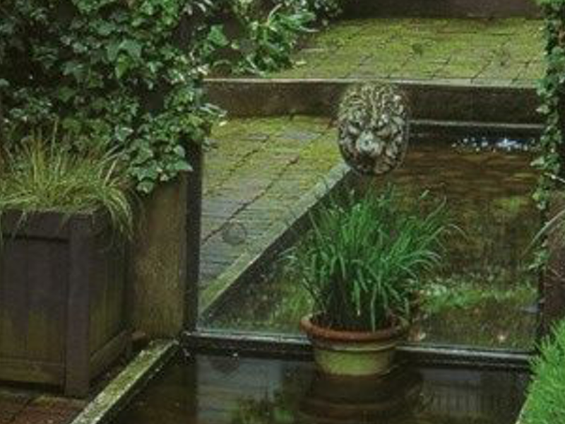 Ein Spiegel erzeugt eine optische Täuschung. Der kleine Teich wirkt größer.