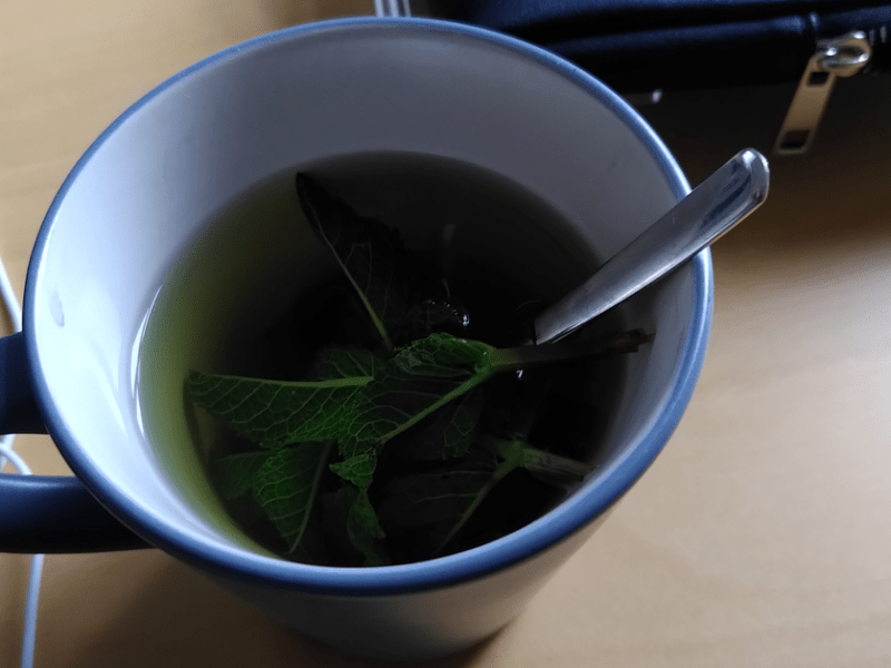 Teetasse mit eine Minze und einem Löffel darin