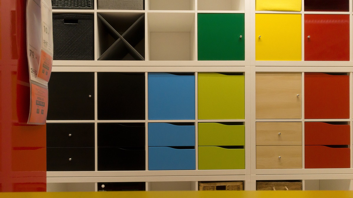 Ein weißes KALLAX-Regal von IKEA, das mit bunten Aufbewahrungsboxen gefüllt ist.