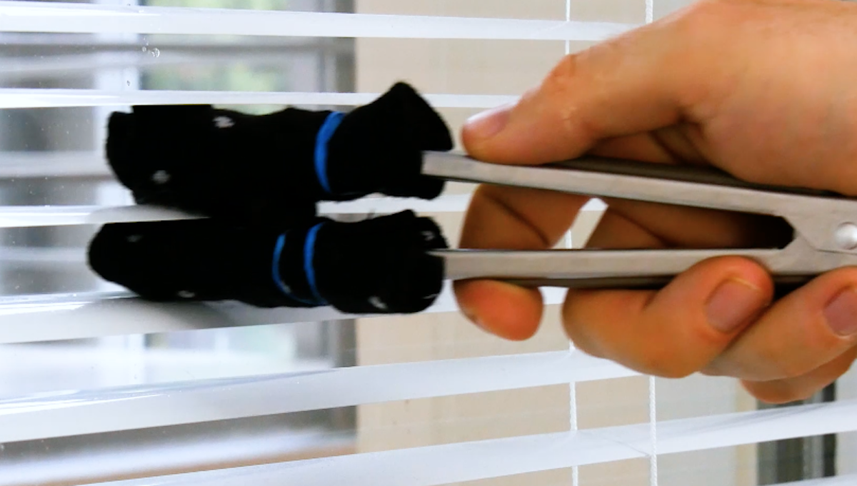 Die Socken mit Wasser einsprühen, um Jalousien kinderleicht zu reinigen