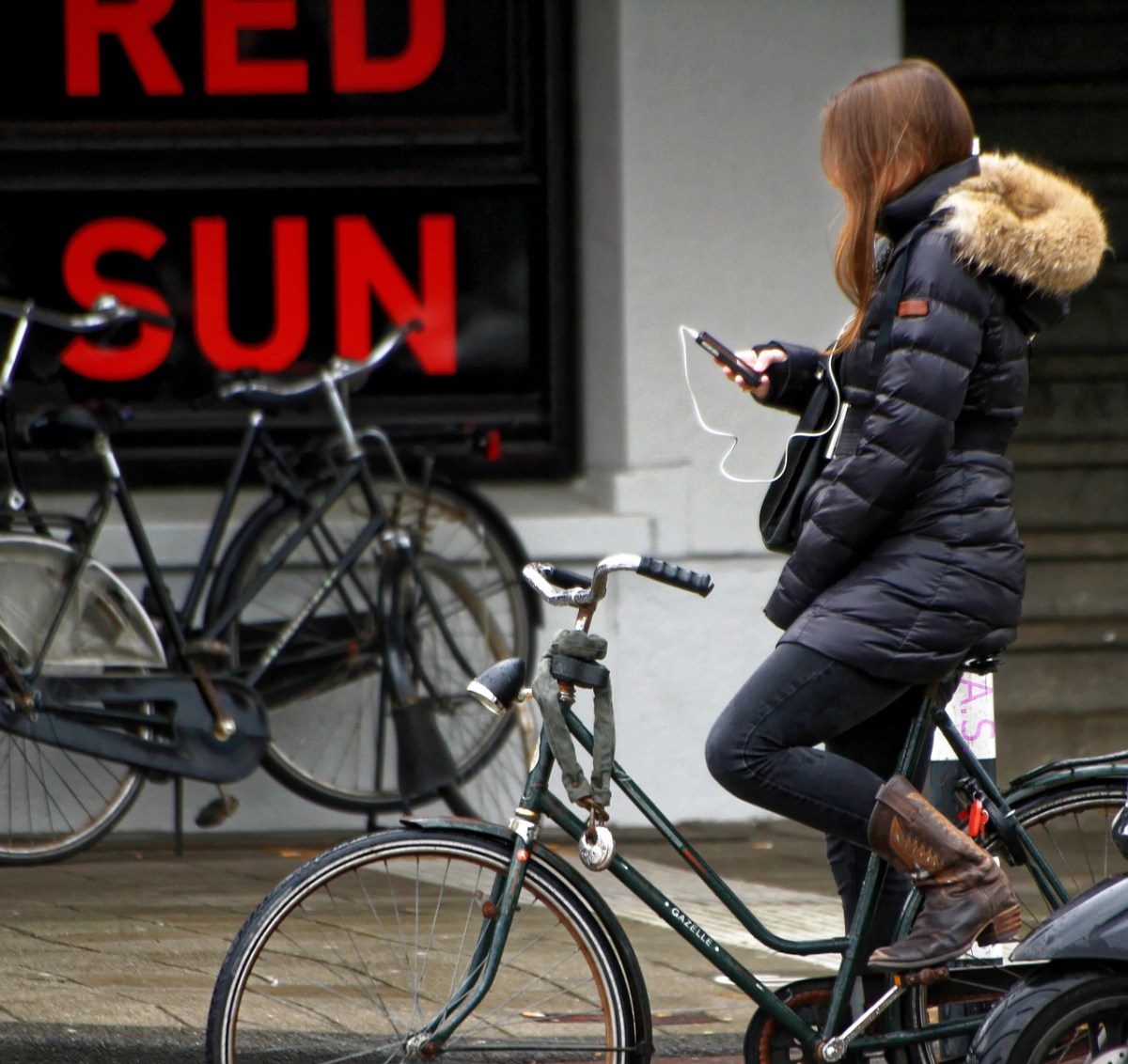 Eine Radfahrerin mit dem Handy in der Hand.