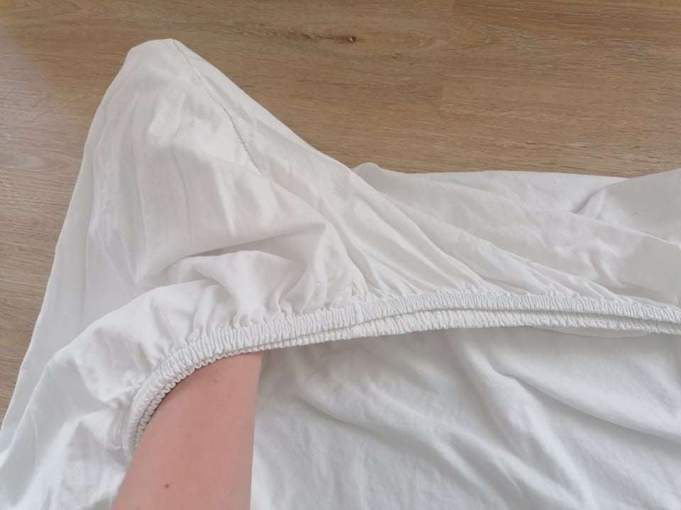 Spannbettlaken wird zusammengelegt.