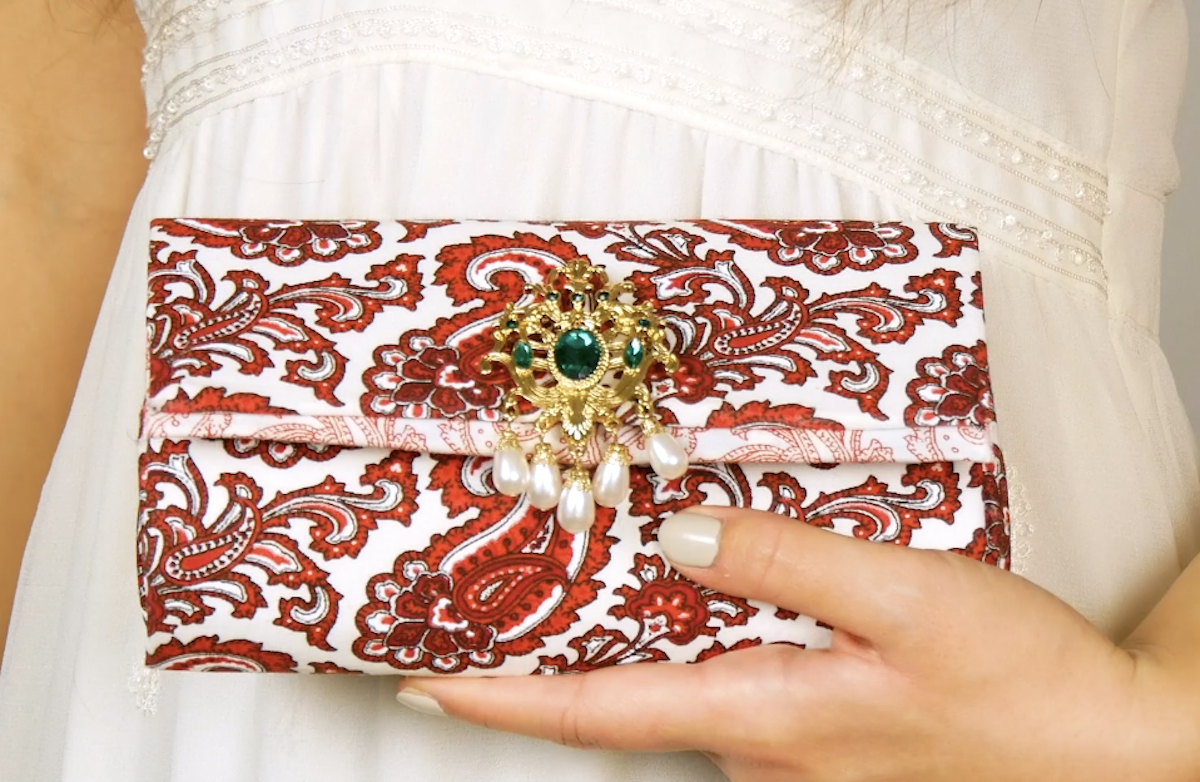 Eine Clutch mit einem filigranen AnhÃ¤nger als Druckknopf.