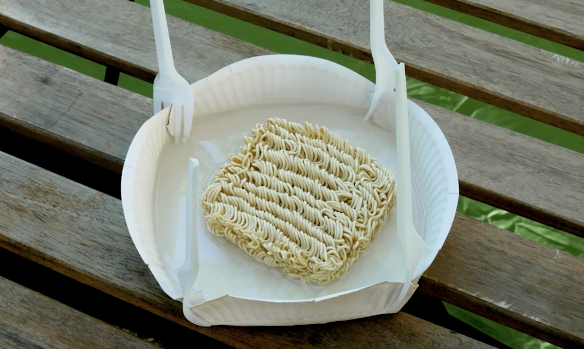 Ein selbstgebauter Suppenteller aus Pappe mit Trockennudeln darauf