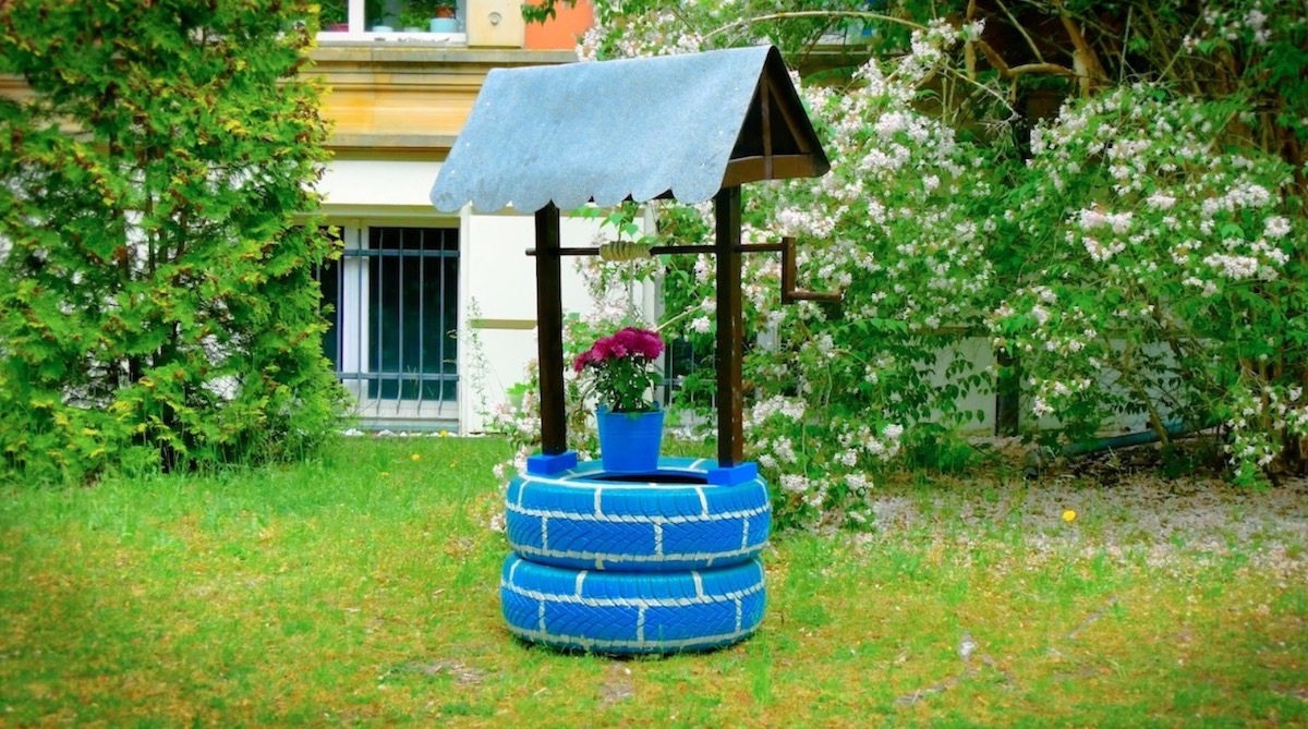 Ein DIY-Brunnen aus Autoreifen in einem Garten.