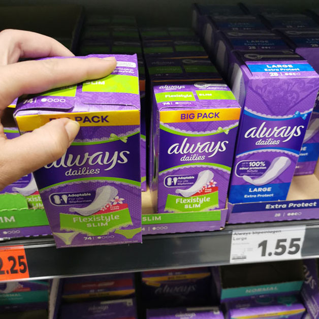 Eine Frau greift nach einer Packung Slipeinlagen im Supermarkt.