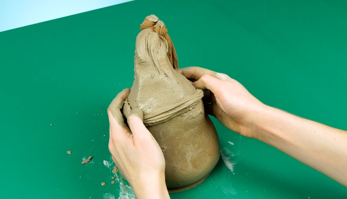 Aus der Strumpfhose mit Zement wird eine Wichtel-Mütze geformt. 