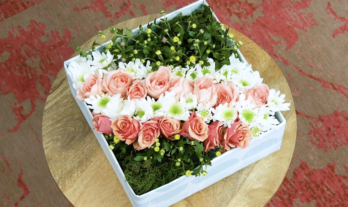 Helle Blumen und GrÃ¼n in einer Box hÃ¼bsch hergerichtet.