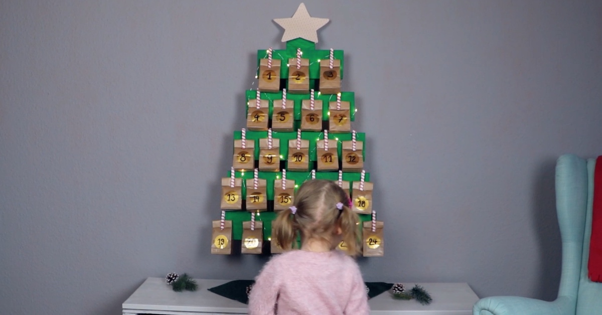 Befestige eine Lichterkette an deinem Adventskalender aus Wäscheklammern und Holz.