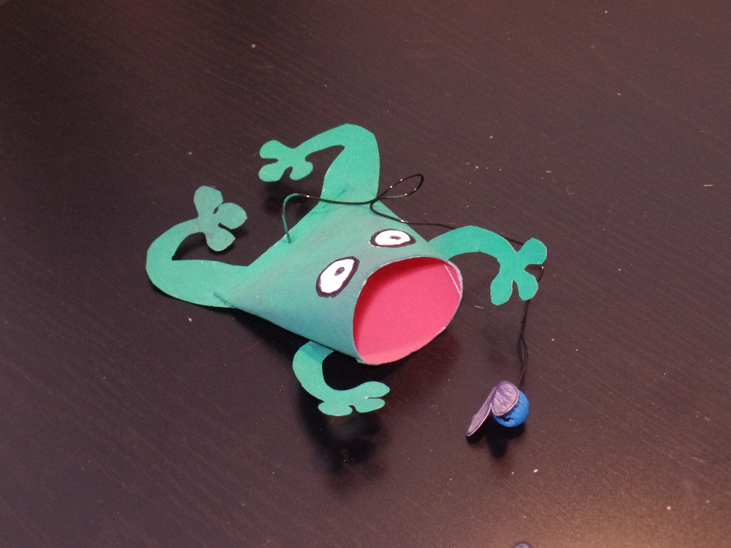 Geschicklichkeitsspiel mit einem Frosch, der aus einer Klopapierrolle gebastelt wurde.