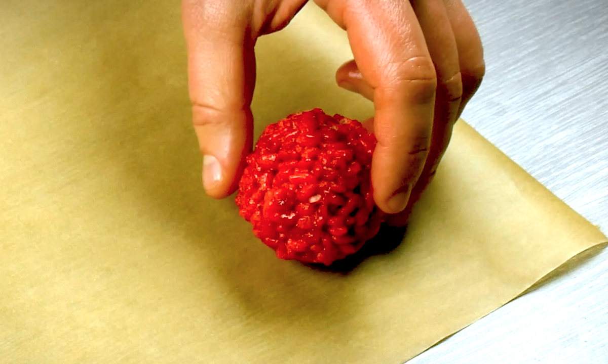 Rote Kugel aus Rice Crispys auf einem Backblech. 