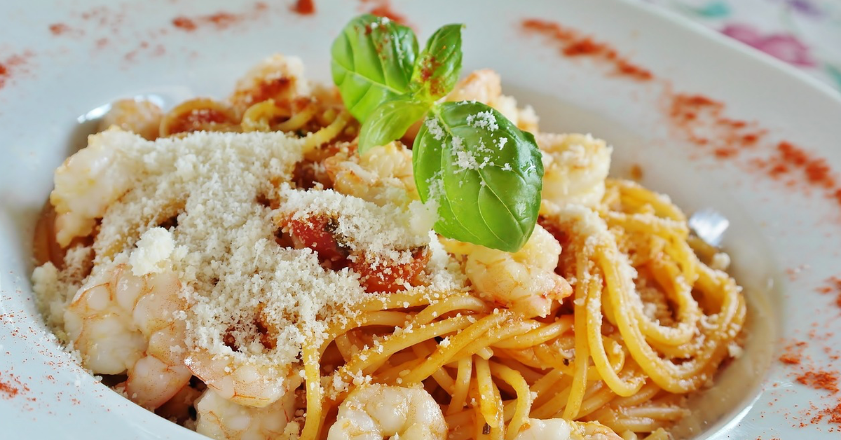 Ein voller Teller Spaghetti mit Parmesan und ein paar Basilikum-BlÃ¤ttern