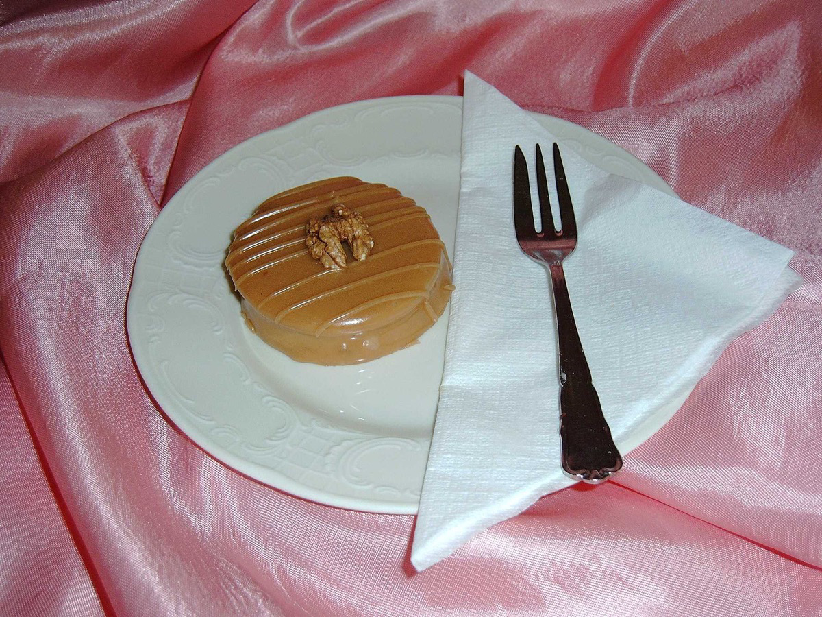 Alltagsfrage oder unnützes Wissen? Kuchengabel mit breiter Seite liegt auf einem Teller mit Süßspeise.