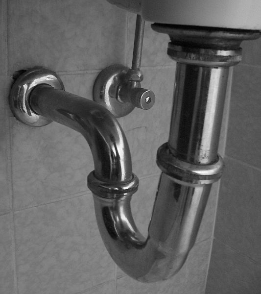 Ein Siphon aus Metall unter einem Waschbecken. Hier findest du 4 verschiedene Methoden, wie du einen Siphon reinigen kannst.