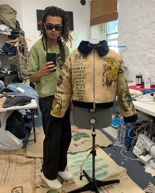 Der Designer präsentiert seine Jacke aus Kaffeesäcken