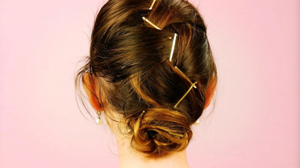 Ein Französischer Zopf mit goldenen Haarspangen.