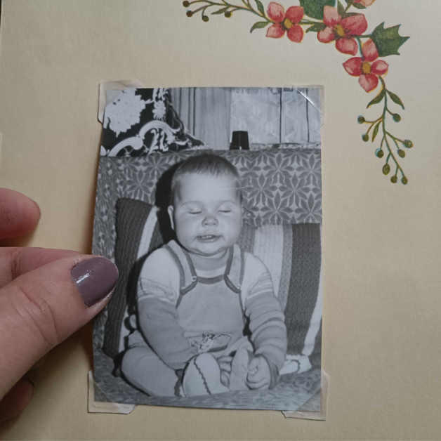 Ein altes Kinderfoto wird einem Fotoalbum entnommen.
