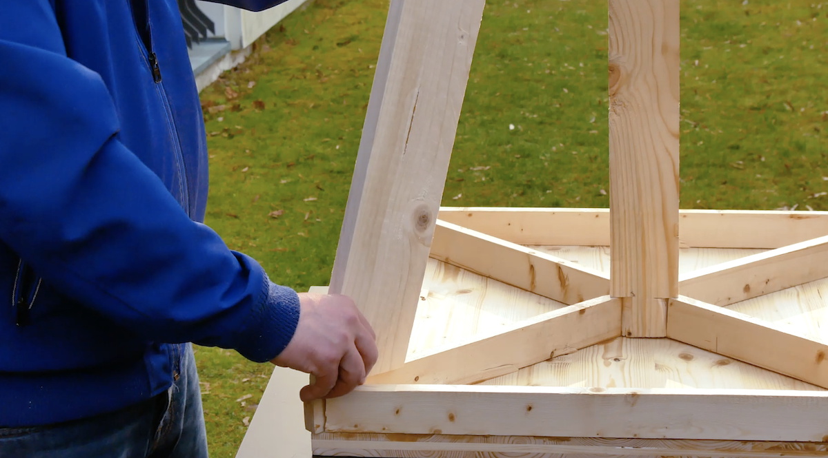 Ein Holzgerüst für einen vertikalen Garten steht auf einem Tisch.