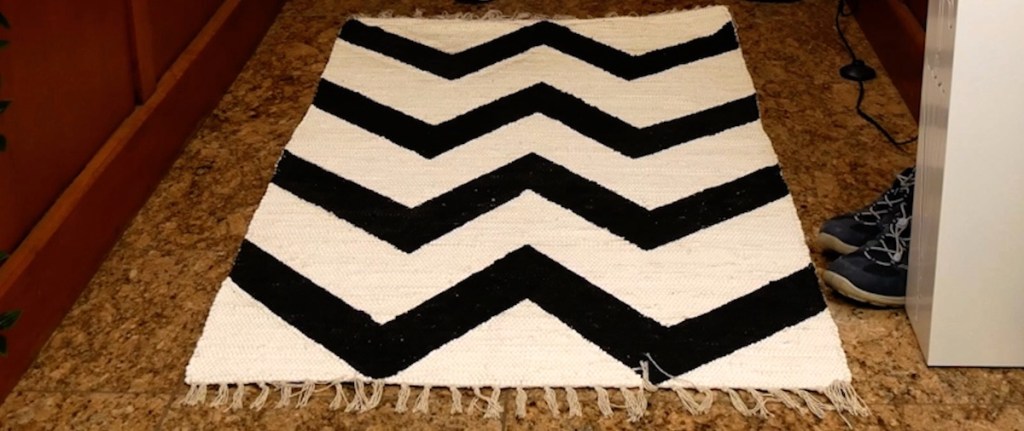 Ein heller Teppich mit dunkel gezacktem Muster.